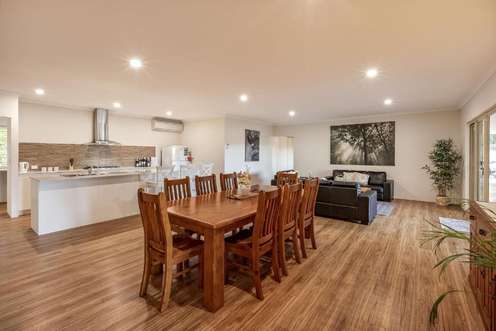 a kitchen and living room with a wooden table and chairs at Villa 16 @ Rivendell Winery Estate - Yallingup in Yallingup Siding