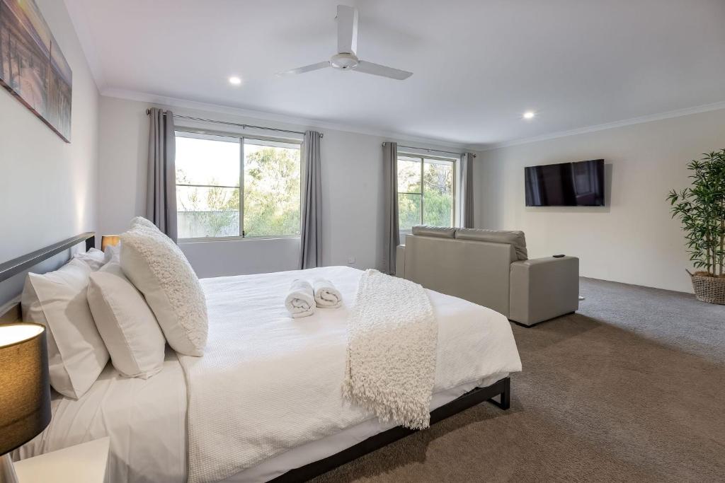 a white bedroom with a bed and a couch at Villa 16 @ Rivendell Winery Estate - Yallingup in Yallingup Siding