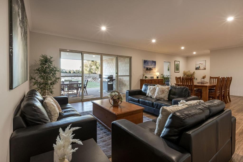 a living room with two couches and a table at Villa 16 @ Rivendell Winery Estate - Yallingup in Yallingup Siding