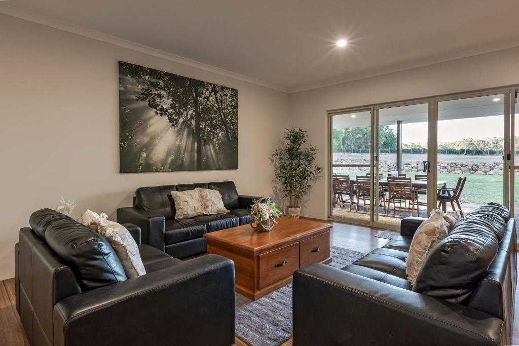 a living room with two couches and a table at Villa 16 @ Rivendell Winery Estate - Yallingup in Yallingup Siding