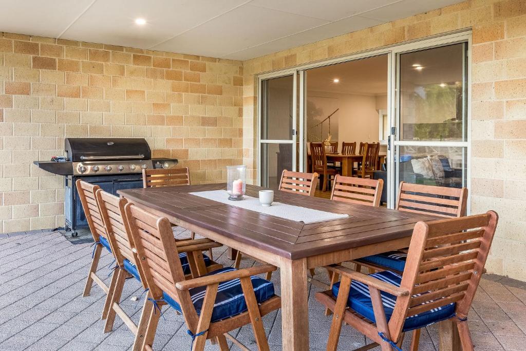 a wooden table and chairs on a patio at Villa 16 @ Rivendell Winery Estate - Yallingup in Yallingup Siding