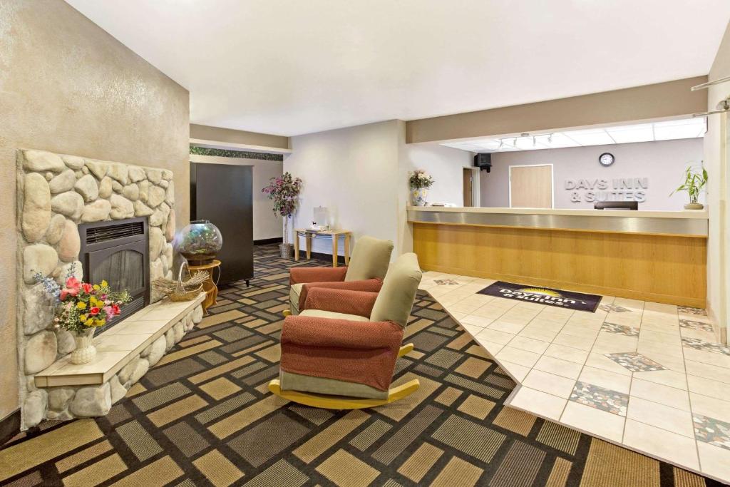 a lobby with a fireplace and chairs and a counter at Days Inn & Suites by Wyndham Castle Rock in Castle Rock