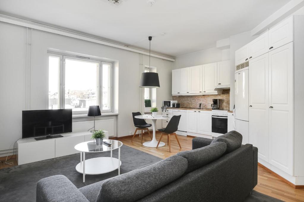 a living room with a couch and a table at Kotimaailma Apartments Kamppi - spacious 1BR in Helsinki
