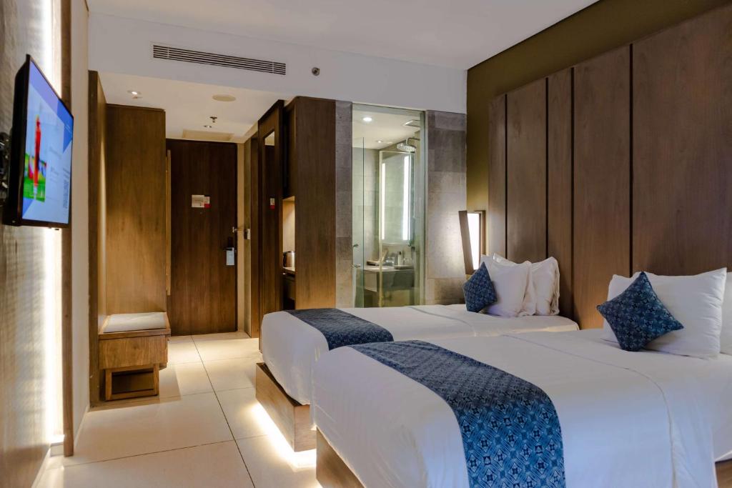 Postel nebo postele na pokoji v ubytování Wyndham Tamansari Jivva Resort Bali
