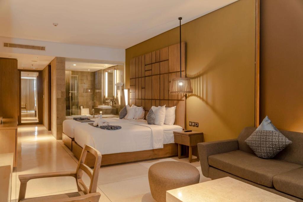 Postel nebo postele na pokoji v ubytování Wyndham Tamansari Jivva Resort Bali
