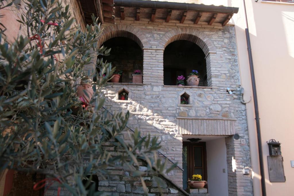 リヴォトルトにあるAppartamenti Il Borgoの鉢植えの窓が三つある建物