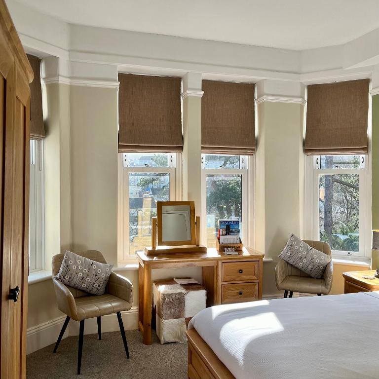 una camera con letto e scrivania con TV di The Devonian a Ilfracombe