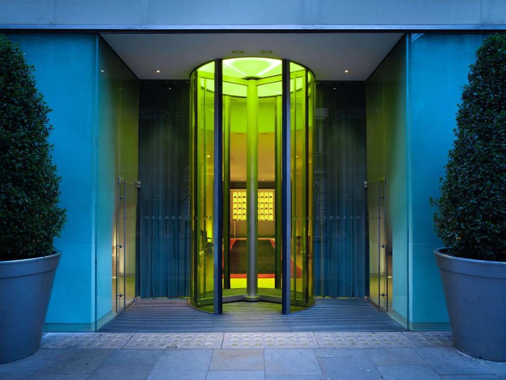 una entrada a un edificio con una puerta giratoria verde en St Martins Lane London en Londres