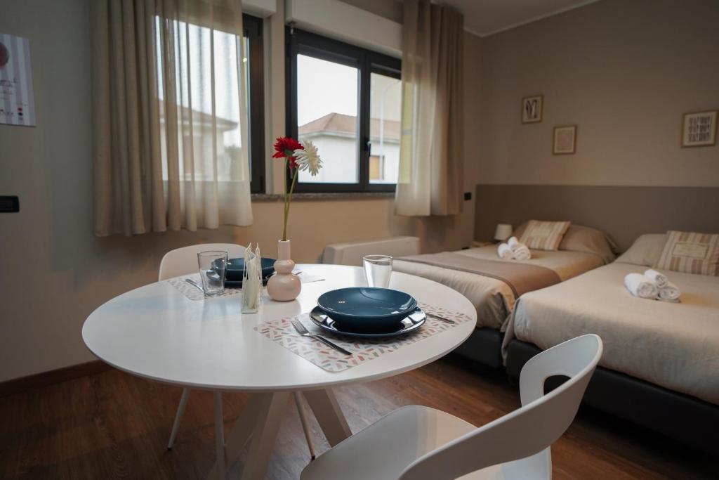 un soggiorno con tavolo e una camera con 2 letti di Bnbook Expo Residence Rho a Rho