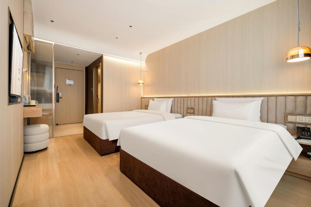 Postel nebo postele na pokoji v ubytování Relax Hotel - Shenzhen Bao'an International Airport