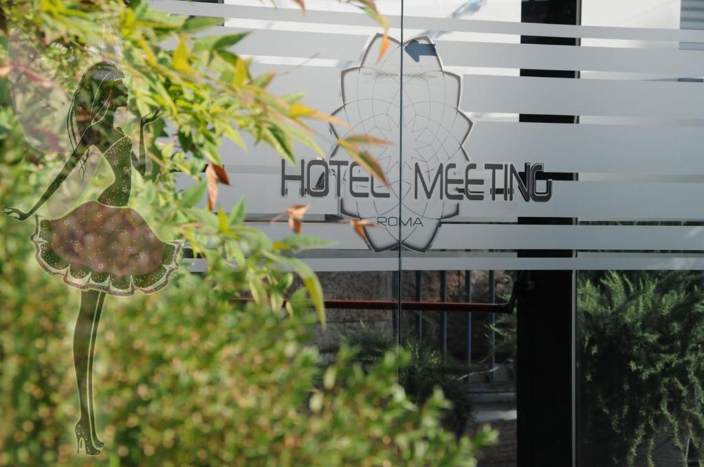 a sign for a hotel meeting in a garden at Hotel Meeting in Ciampino