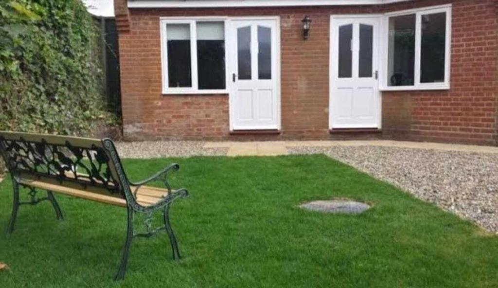 a bench in a yard with two white doors at The Butchers Arms Freehouse in Leiston