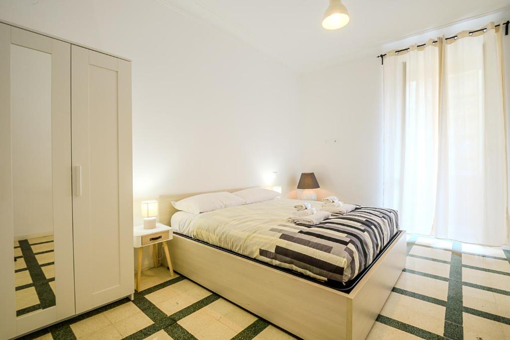 - une chambre blanche avec un lit et une fenêtre dans l'établissement Galazia Apartment San Giovanni, à Rome