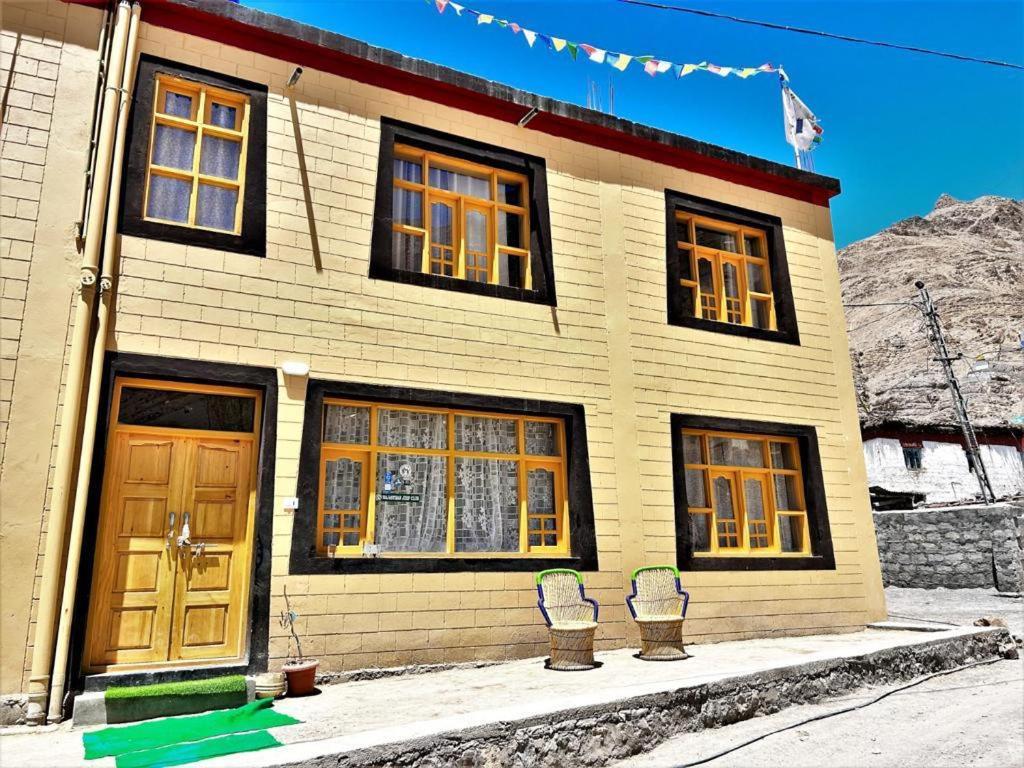 a house with two chairs in front of it at Green Tara Mud House by StayApart in Kaza