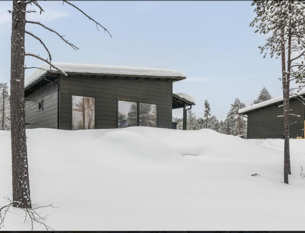 une maison avec un tas de neige devant elle dans l'établissement Villa Lusma, à Inari