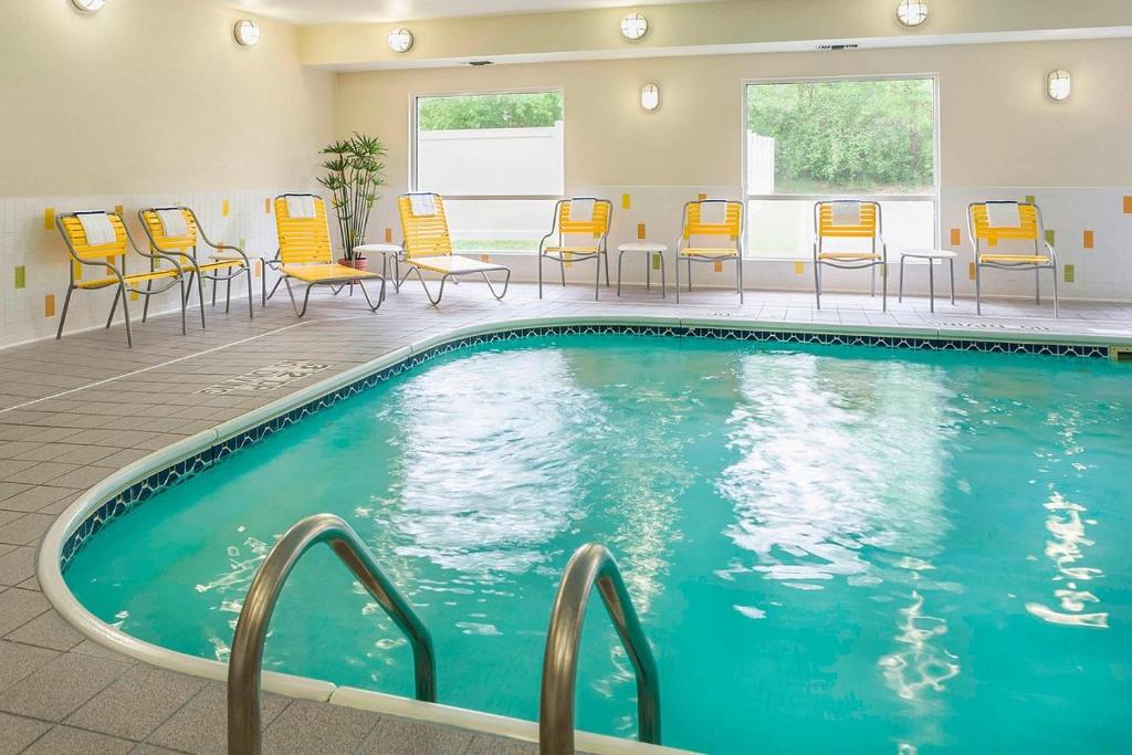 a pool in a hotel room with chairs and tables at Fairfield by Marriott in Jackson