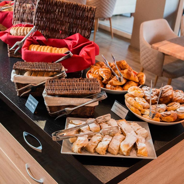 a buffet with different types of bread and pastries at The Hotel Unforgettable - Hotel Tiliana by Homoky Hotels & Spa in Budapest