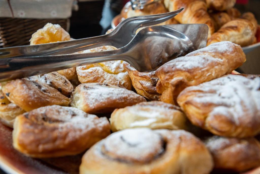 a plate of pastries with a spatula on top at The Hotel Unforgettable - Hotel Tiliana by Homoky Hotels & Spa in Budapest
