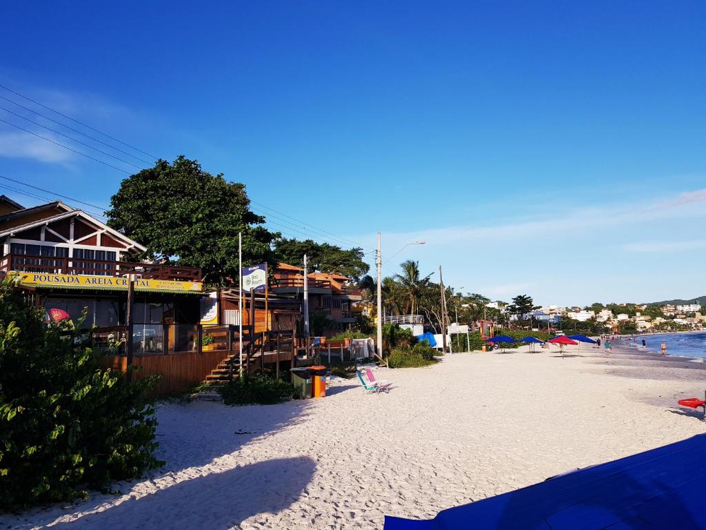 una playa con casas y sillas y el océano en Pousada Areia Cristal, en Bombinhas