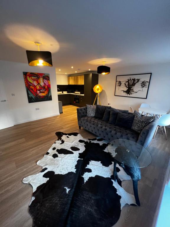 uma sala de estar com um sofá e um tapete de vaca em Modern and spacious two bedroom apartment near city centre em Bristol