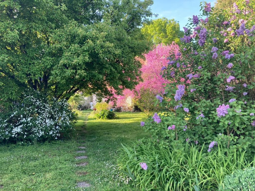 een tuin met kleurrijke bloemen en bomen bij Chambres d'hôtes La Ferme du Grand Launay in Semblançay