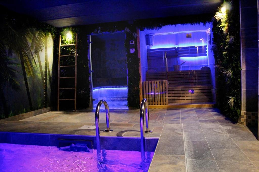bañera con luces moradas frente a un edificio en Pool47spa, en Précy-sur-Oise