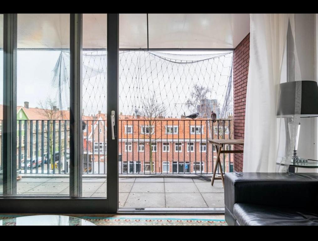 una puerta de cristal abierta con vistas a un edificio en 4-bedroom large spacious apartment, en Ámsterdam