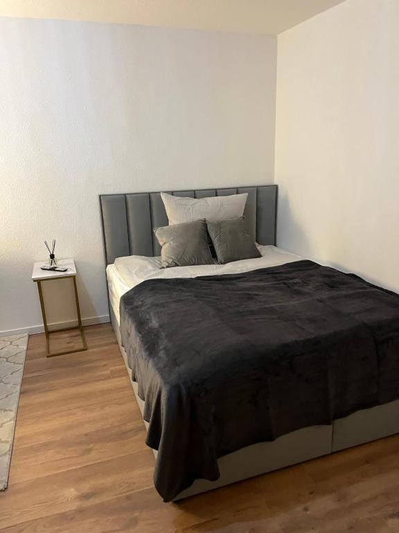カールスルーエにあるCity Appartement direkt am Schloss!のベッドルーム1室(大型ベッド1台、黒い毛布付)