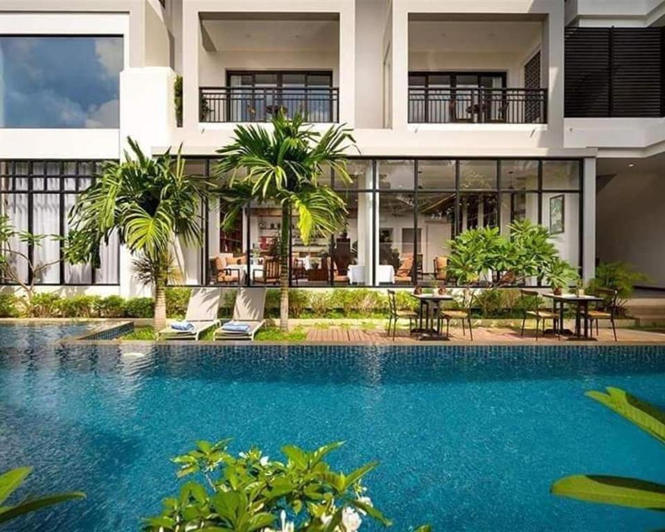 uma piscina em frente a um edifício em Angkor Style Resort & Spa em Phumĭ Ta Phŭl