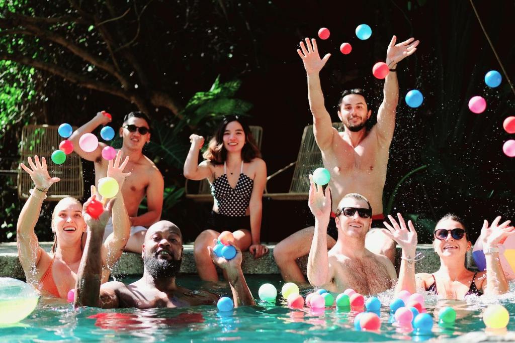 un grupo de personas en la piscina con bolas en el agua en Mad Monkey Dumaguete, en Dumaguete