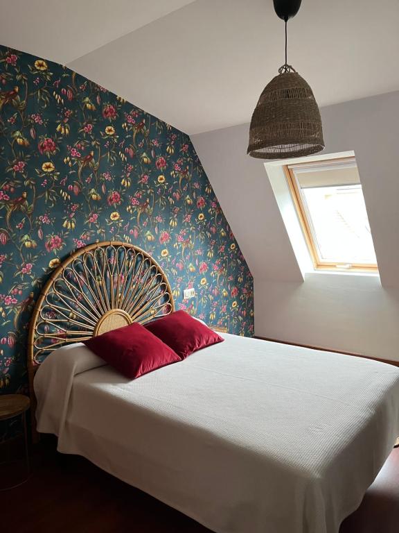 a bedroom with a bed with a floral wall at Casa das Sereas in Laxe