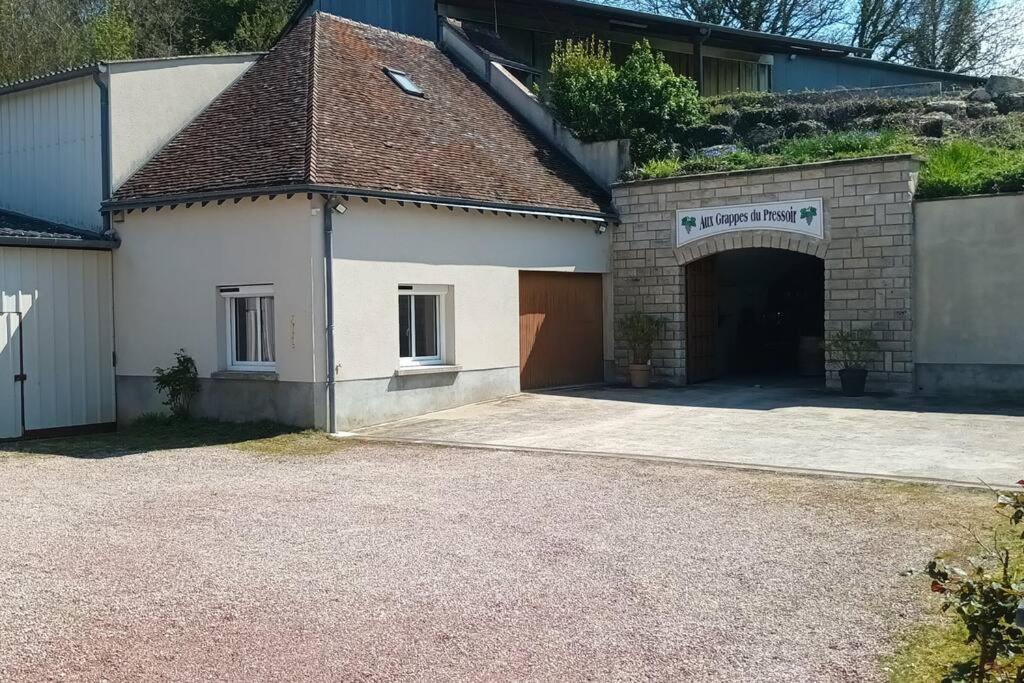 un bâtiment avec un garage et une allée dans l'établissement *Gîte Aux Grappes du Pressoir* à 2 km de Beauval, à Seigy