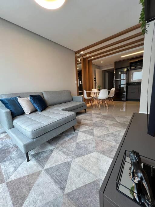 a living room with a couch and a table at Loft lindo de alto padrão in Capão da Canoa