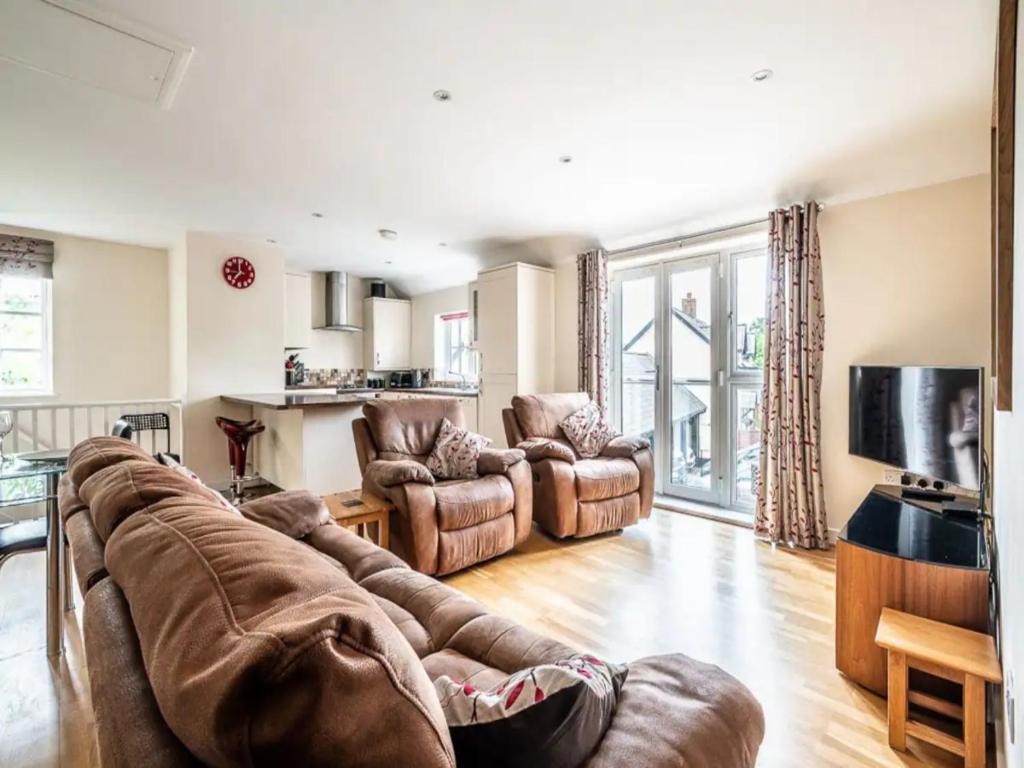 a living room with a couch and chairs and a television at Spacious modern home in picturesque village in Exeter