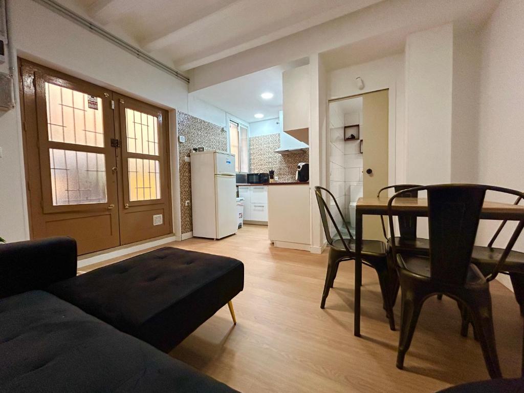 ein Wohnzimmer mit einem Tisch und einer Küche in der Unterkunft Barceloneta beach house in Barcelona