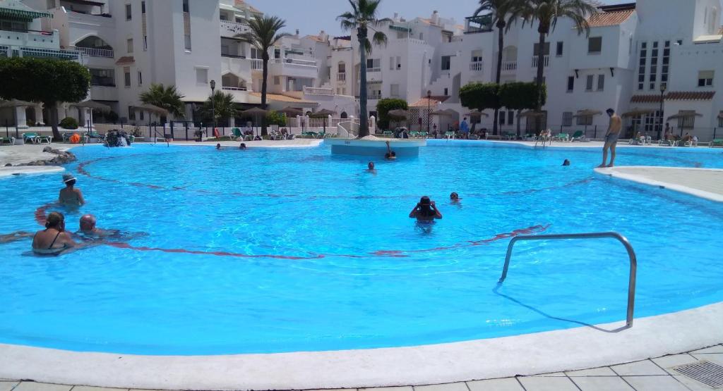 a group of people in a large blue swimming pool at APARTAMENTO PUERTO GOLF in Almerimar