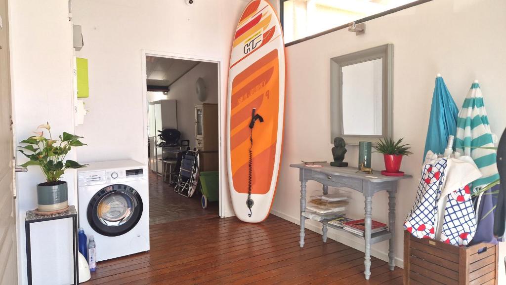 a room with a surfboard hanging on the wall at Le Transat in Palavas-les-Flots