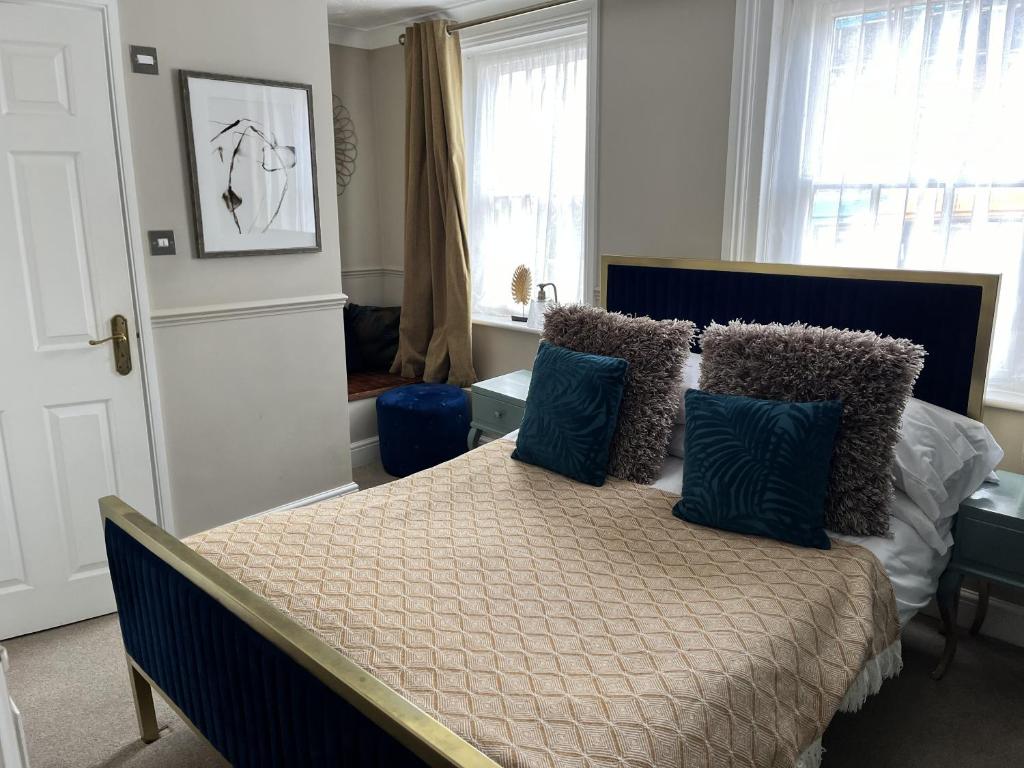 a bedroom with a bed with blue pillows on it at The Ship Hotel in New Romney