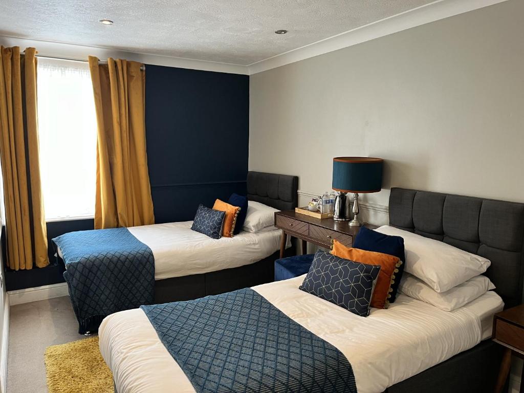 a hotel room with two beds and a couch at The Ship Hotel in New Romney