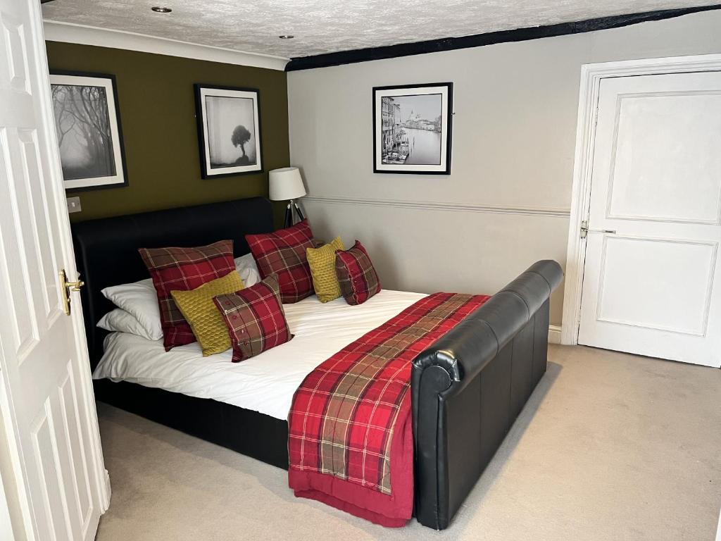 a bedroom with a bed with a plaid blanket at The Ship Hotel in New Romney