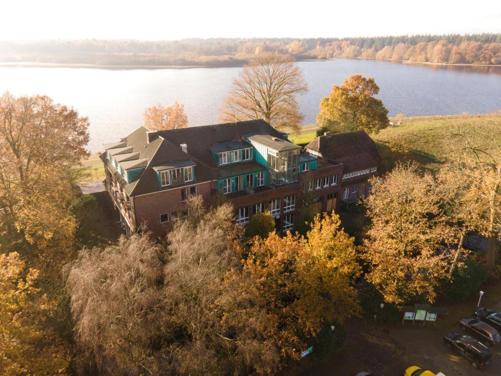 an aerial view of a house next to a lake at Hotel Seeblick in Thülsfeld