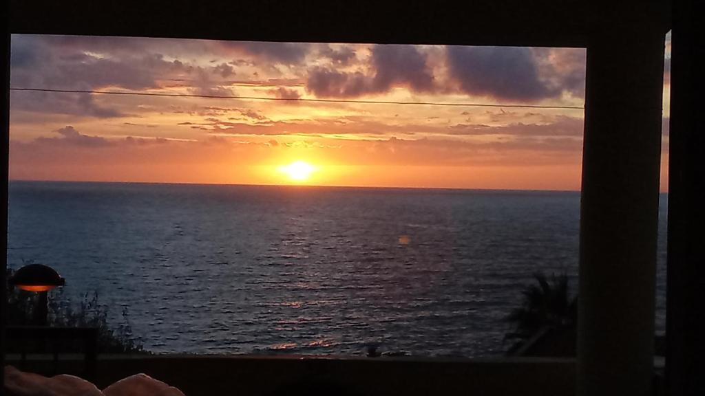a sunset view from a window of the ocean at Extra lokacija!!!!! in Sutomore