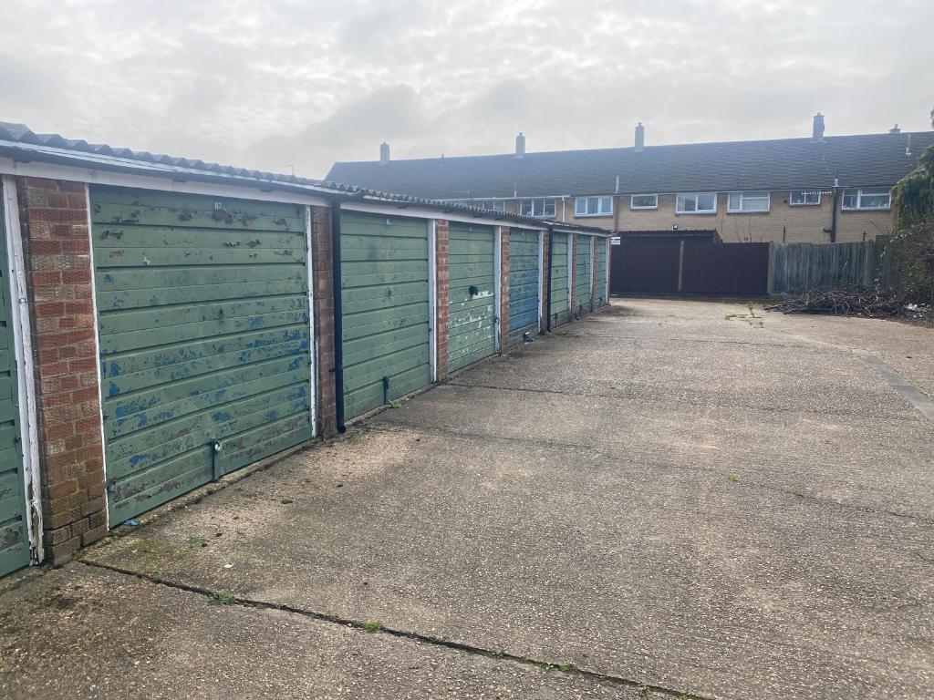 una fila de puertas verdes de garaje en un edificio en Garage for rent as storage or keep your car, none suitable for living en Stanwell