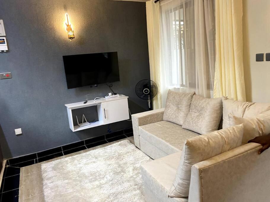 1bedroom@Pacho0725913803 في كيزيمو: غرفة معيشة مع أريكة وتلفزيون