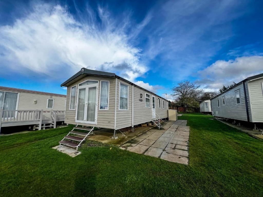 a tiny house in a yard with two mobile homes at Lovely Caravan At Manor Park, Nearby Hunstanton Beach In Norfolk Ref 23067s in Hunstanton