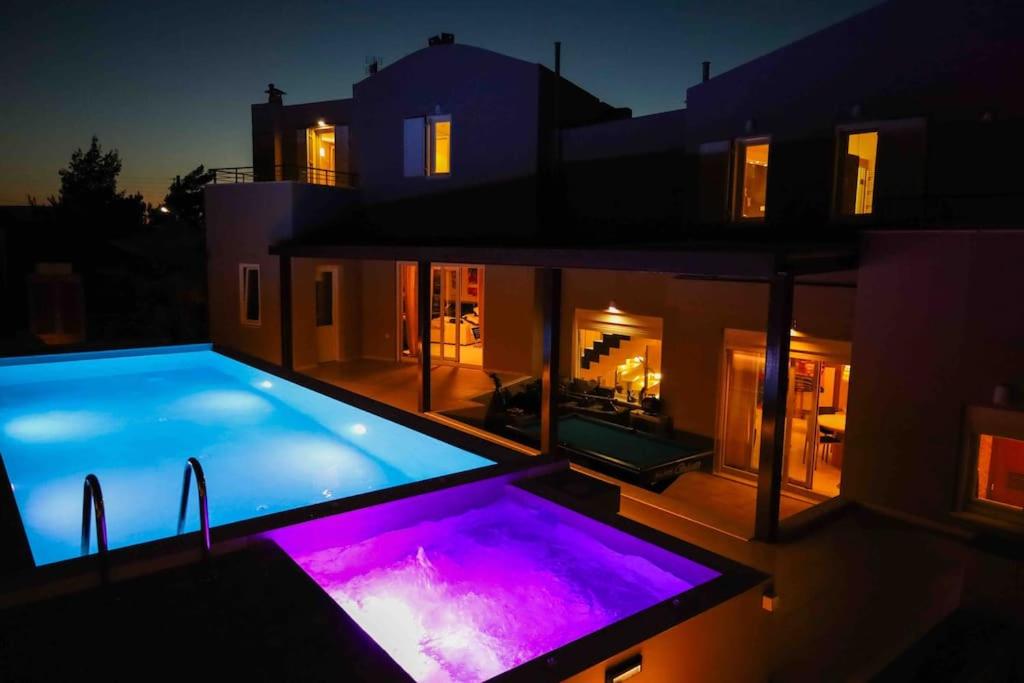 a house with a large swimming pool at night at Villa Meli in Hersonissos