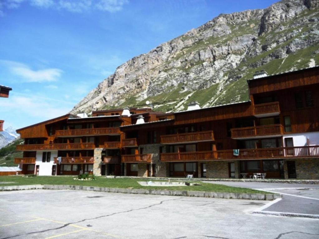 a large building in front of a mountain at Résidence Hameaux De Val - 2 Pièces pour 6 Personnes 004 in Val-d'Isère