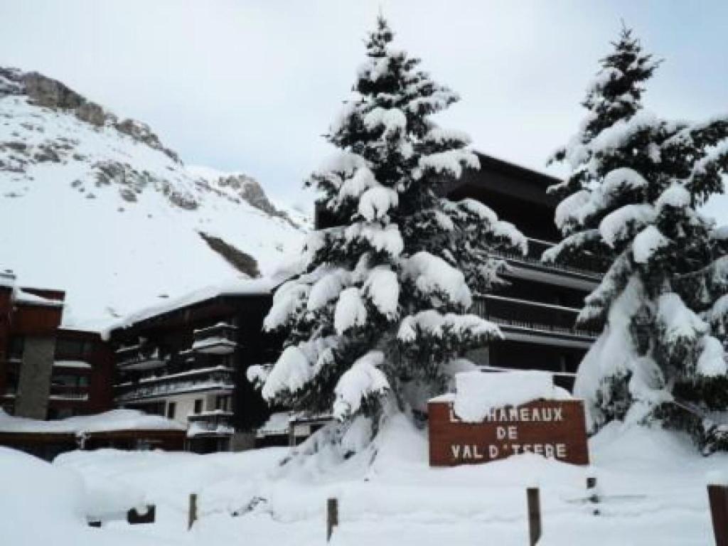 a ski lodge with snow covered trees and a sign at Résidence Hameaux De Val - 2 Pièces pour 6 Personnes 004 in Val-d'Isère