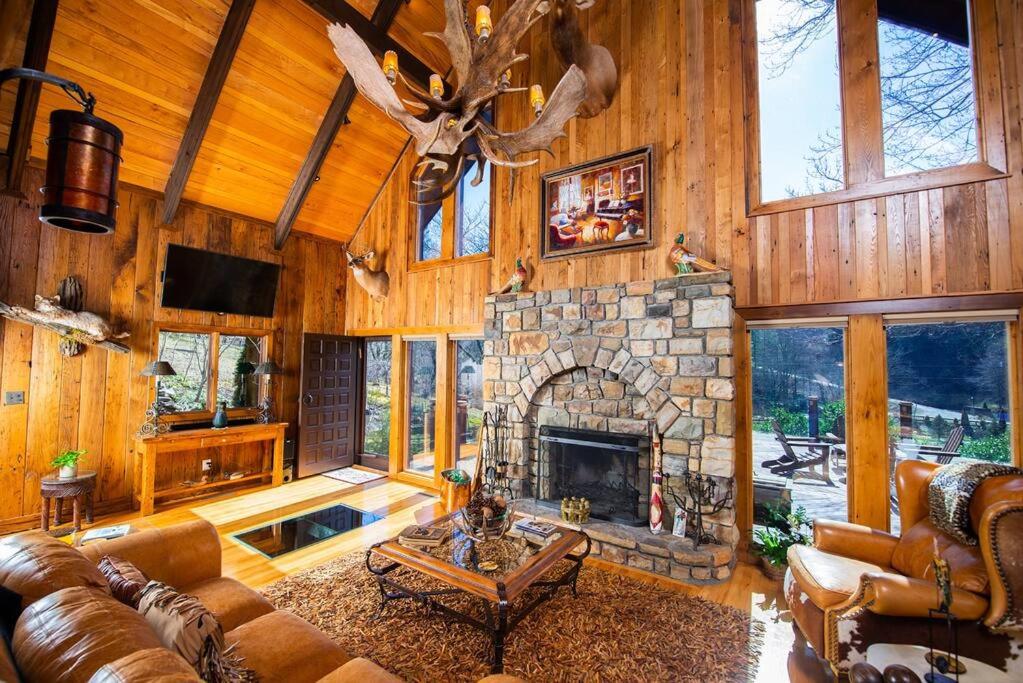 una gran sala de estar con chimenea de piedra. en LUXURY!! Hot Tub, Pool Table, River & Petting zoo?, en Sugar Grove