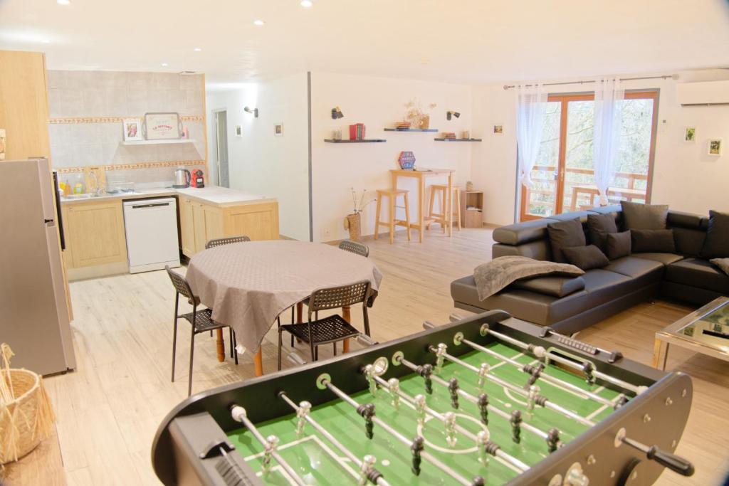 a living room with a pool table and a kitchen at Chalet en pleine nature Pomerol in Pomerol